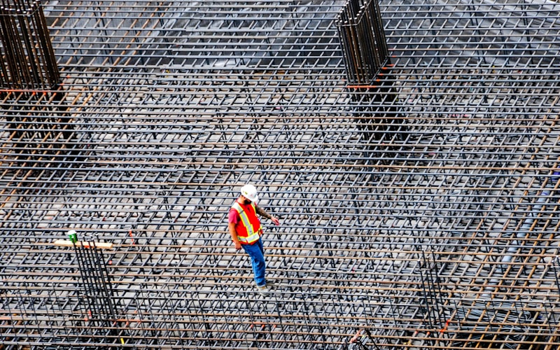 Construction worker inspecting rebar on a commercial building site